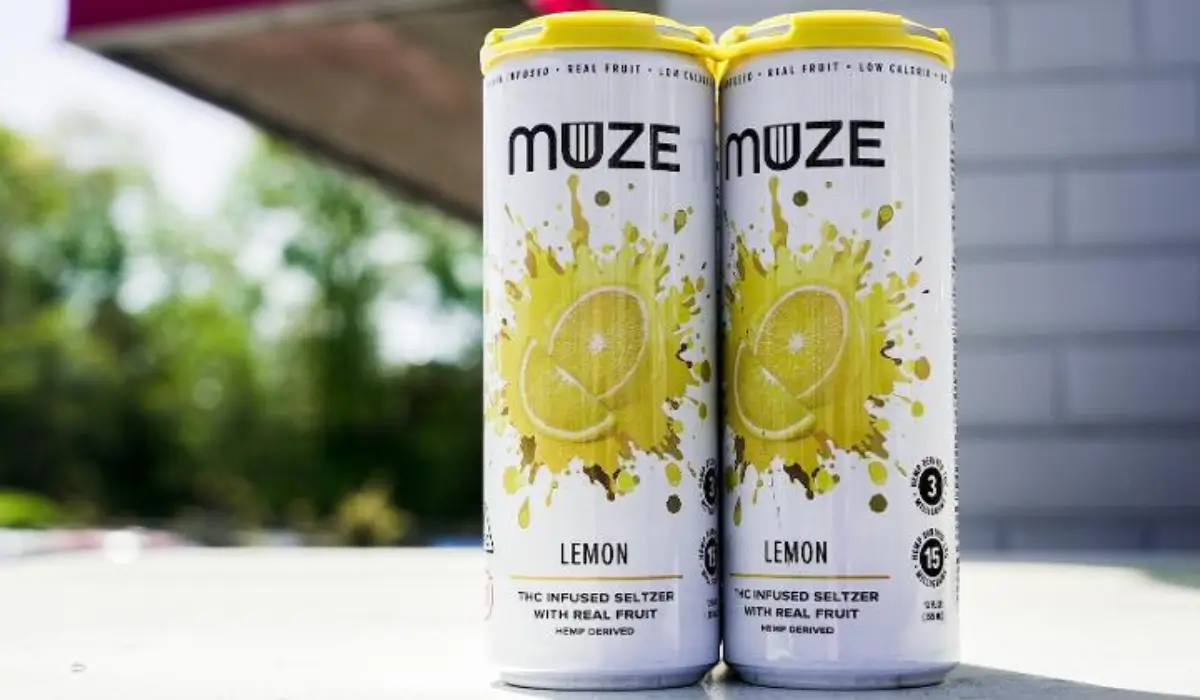 Two cans of MUZE lemon THC-infused seltzer displayed outdoors on a table.