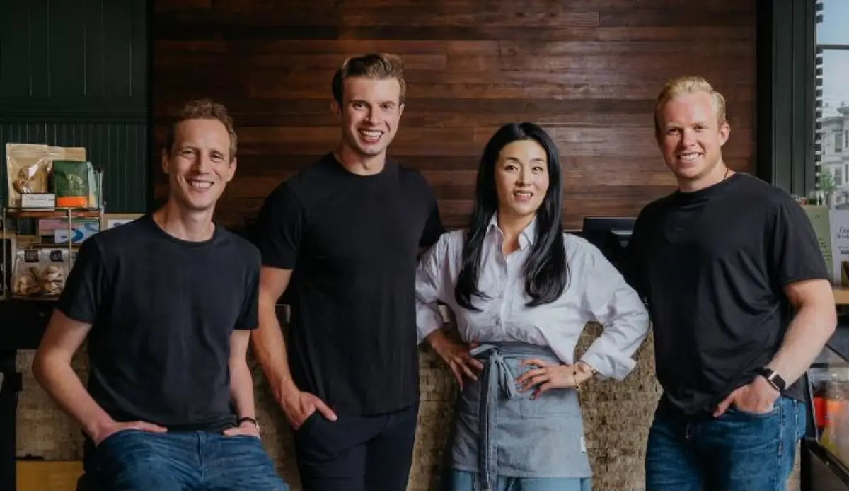 Four Owner team members standing inside a restaurant as the company expands its AI technology for independent restaurants.